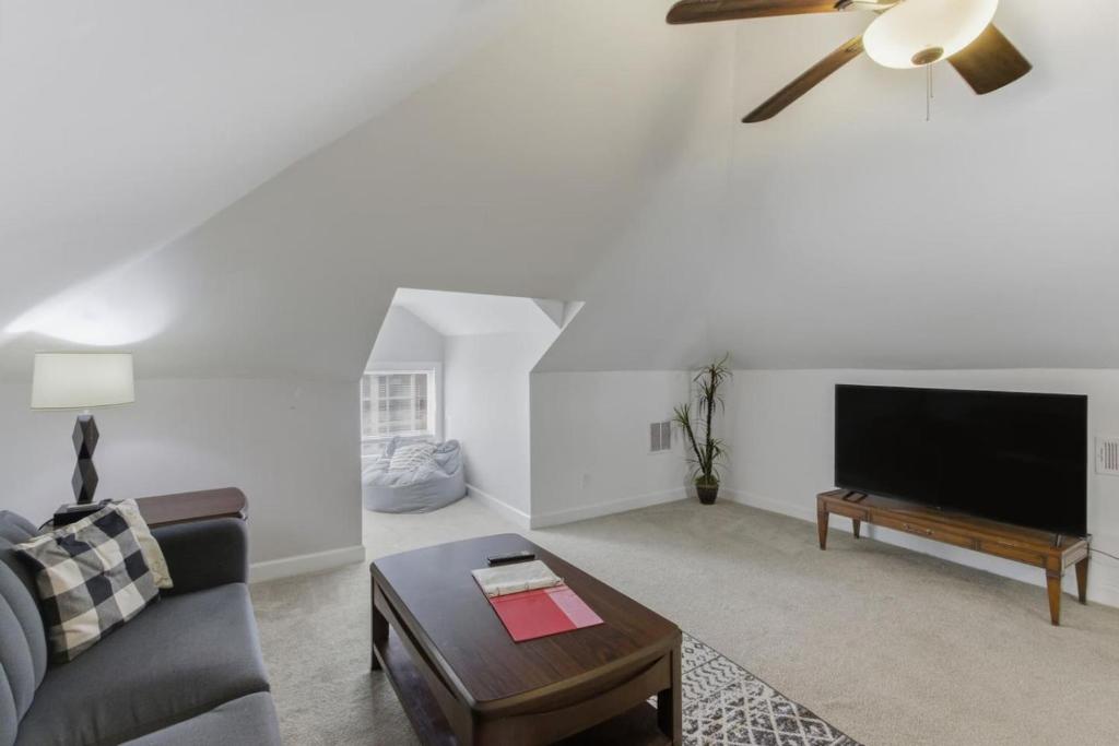 Una sala de estar con un sofá y un televisor de pantalla plana. en The Hideout Loft - Tranquil Stay, en Memphis