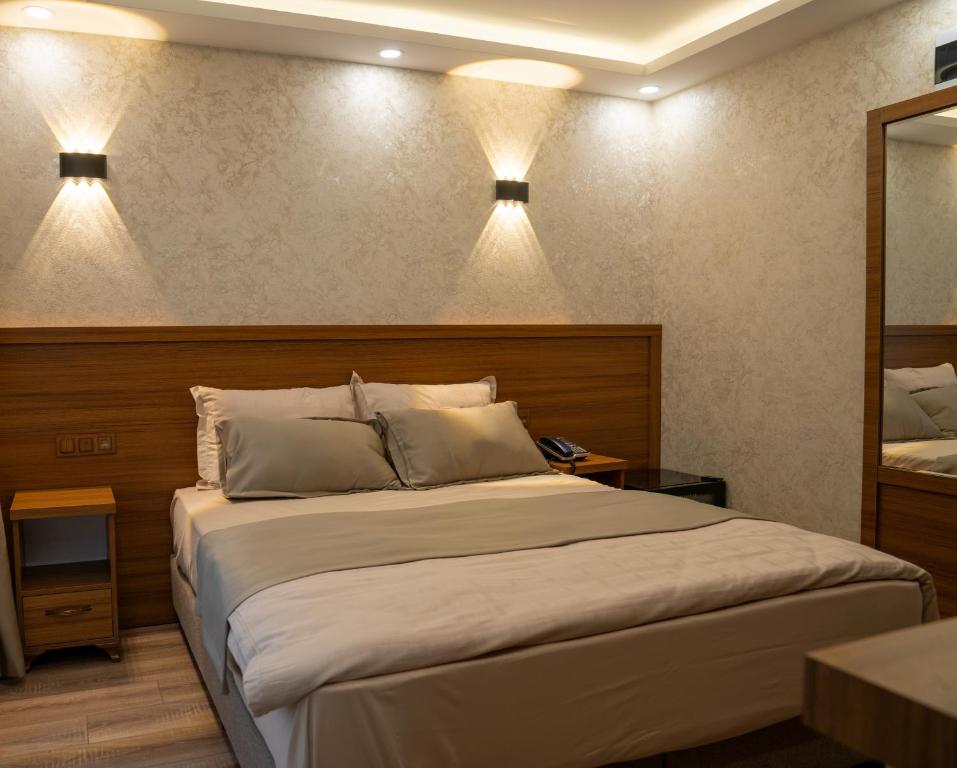 a bedroom with a bed with two lights on the wall at Zirvesta Otel in Istanbul