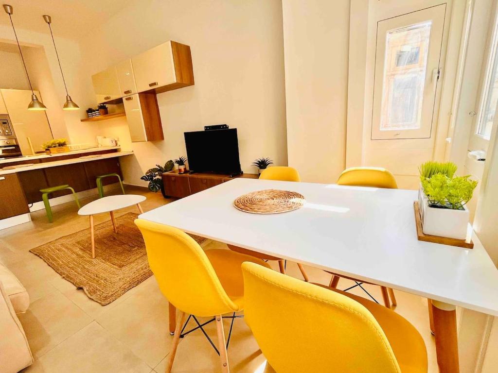una cucina e una sala da pranzo con tavolo e sedie gialle di Sunny house by the sea a Taʼ Xbiex