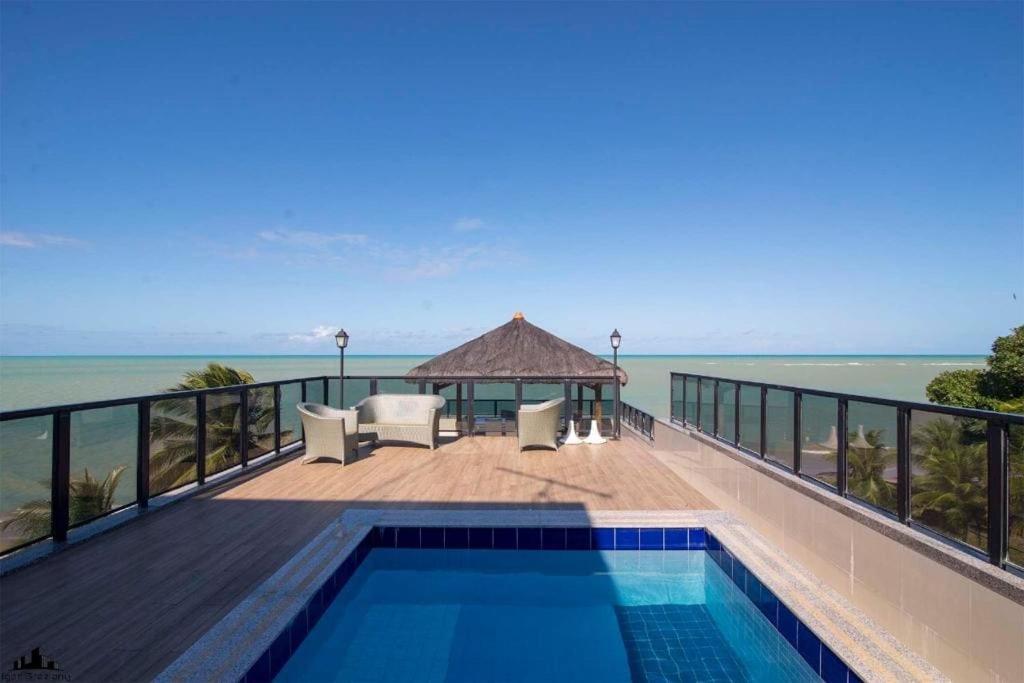 einen Pool mit Pavillon und Meerblick in der Unterkunft Cobertura pé na areia com piscina exclusiva única in João Pessoa