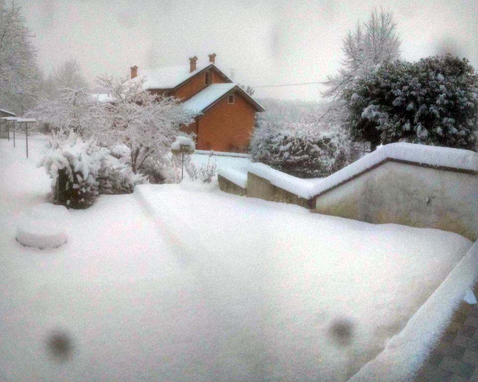 um quintal coberto de neve com uma casa em Dolomitiloungebelluno Mountain resources em Belluno