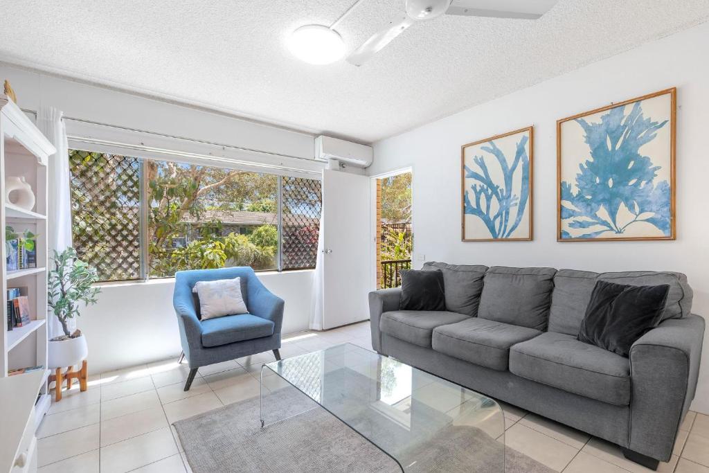 un soggiorno con un divano e una poltrona di Relaxed Beachside Escape on the Ground Floor Sandcastles 201 a Coffs Harbour