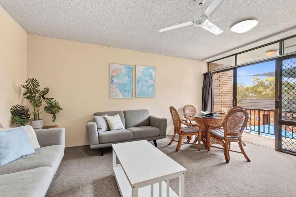 un soggiorno con un divano e un tavolo di Beachside Retreat with Resort Pool & Spa Access Sandcastles 224 a Coffs Harbour