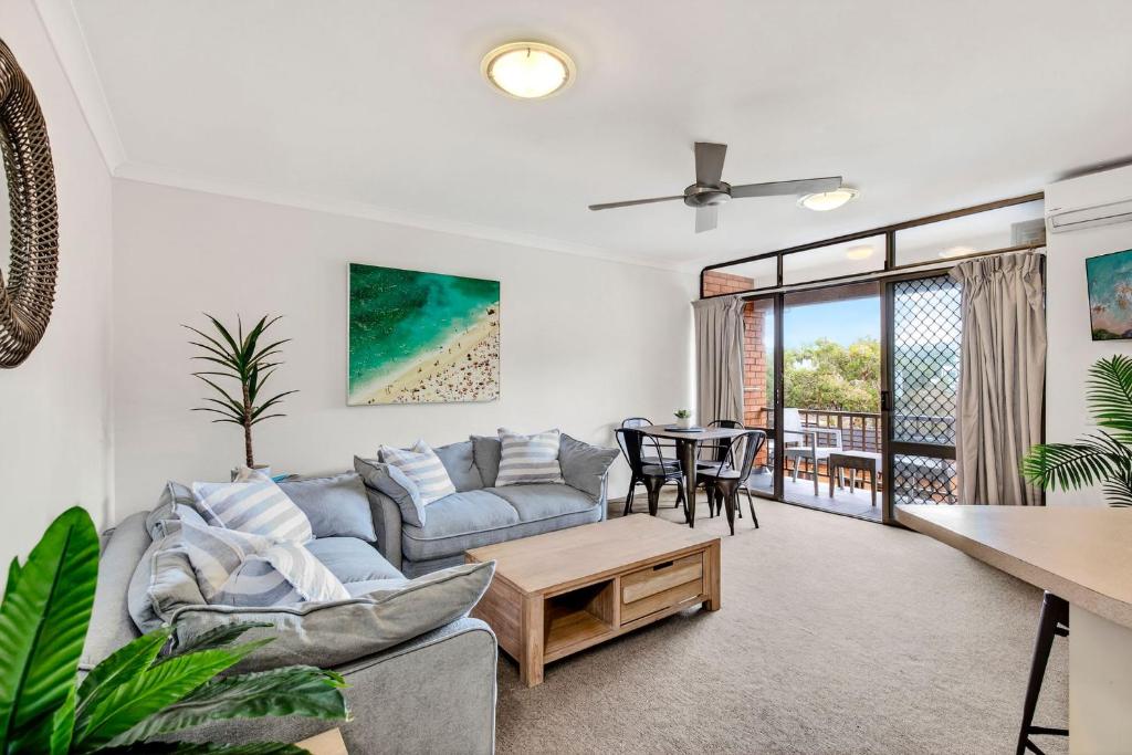 un soggiorno con un divano e un tavolo di Beachside Escape with Resort Facilities Sandcastles 226 a Coffs Harbour