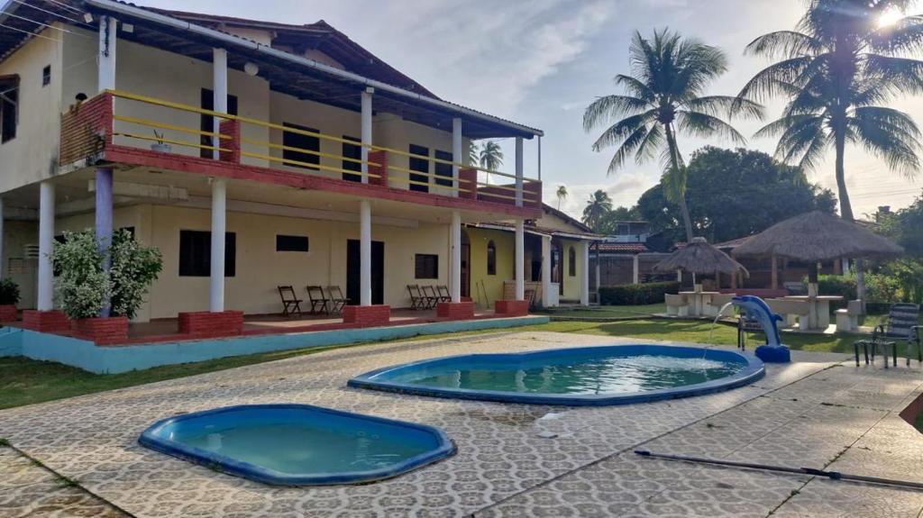 una villa con piscina frente a una casa en Pousada Encantos de Paripueira, en Paripueira