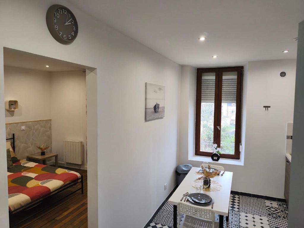 a bedroom with a bed and a clock on the wall at Cozy Studio avec Parking Charleville in Charleville-Mézières