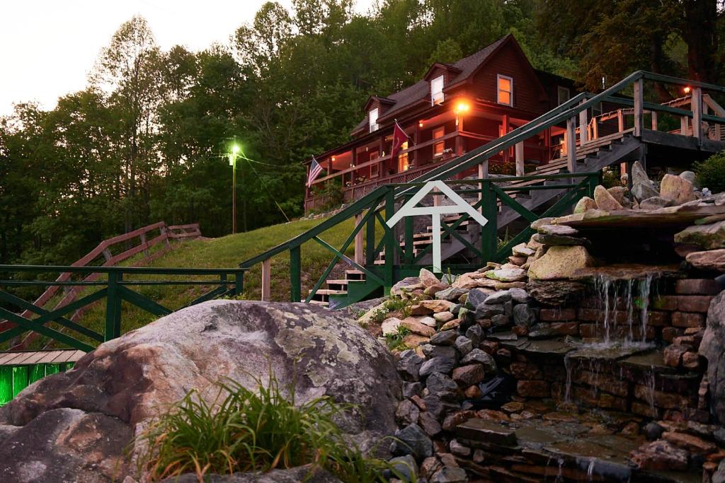 a house with a waterfall in front of a building at Mountain Harbour B&B in Roan Mountain
