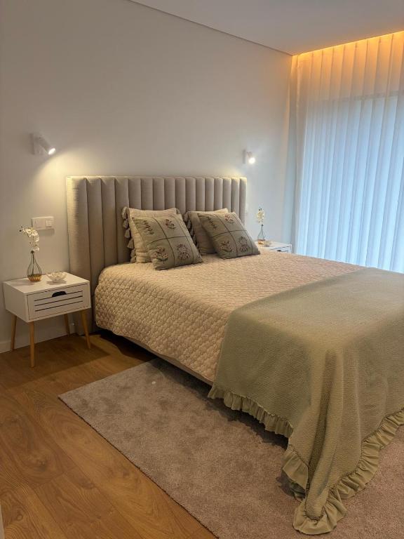 a bedroom with a large bed and a window at Casa Maria Eduarda in Assureira