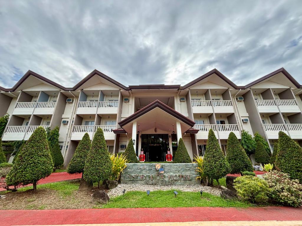 D' Leonor Inland Resort and Adventure Park في مدينة دافاو: مبنى كبير مع حديقة أمامه
