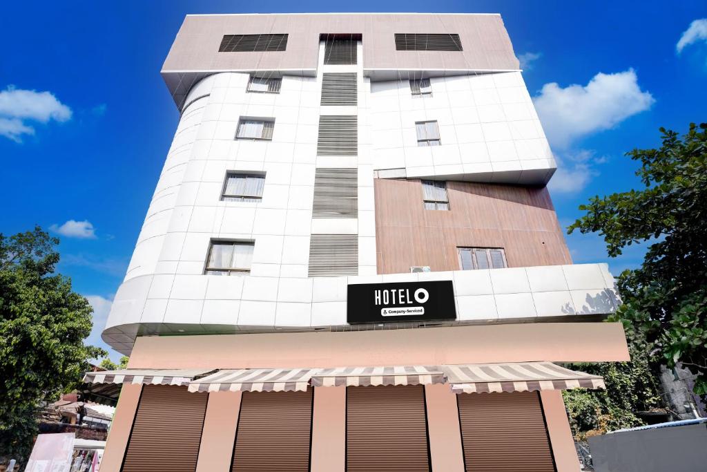 a tall building with a mitzo sign on it at Super Hotel O Nashik Road Formerly The Address Hotel in Nashik
