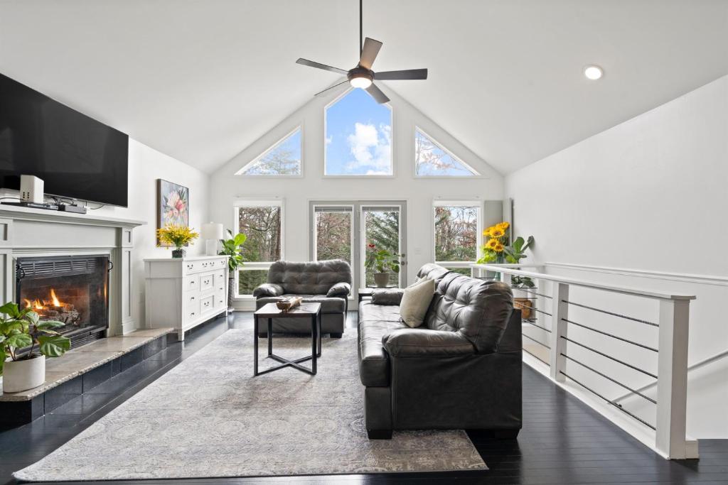 ein Wohnzimmer mit Couch und Kamin in der Unterkunft Hawk Mountain Song- Massanutten Home with hot tub! in Massanutten