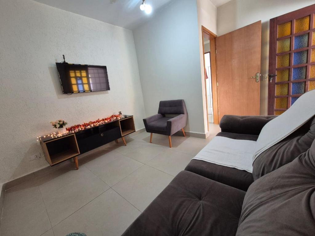 a living room with a couch and a chair at Casa Praia Bertioga in Bertioga
