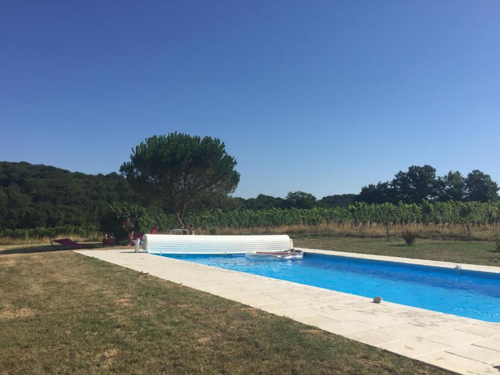uma piscina num campo ao lado de um quintal em Maison du Guit em Viella
