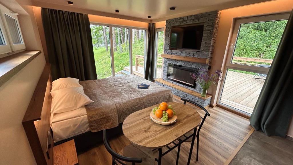 a living room with a table and a room with a fireplace at Kolme Männi Kuubik in Otepää