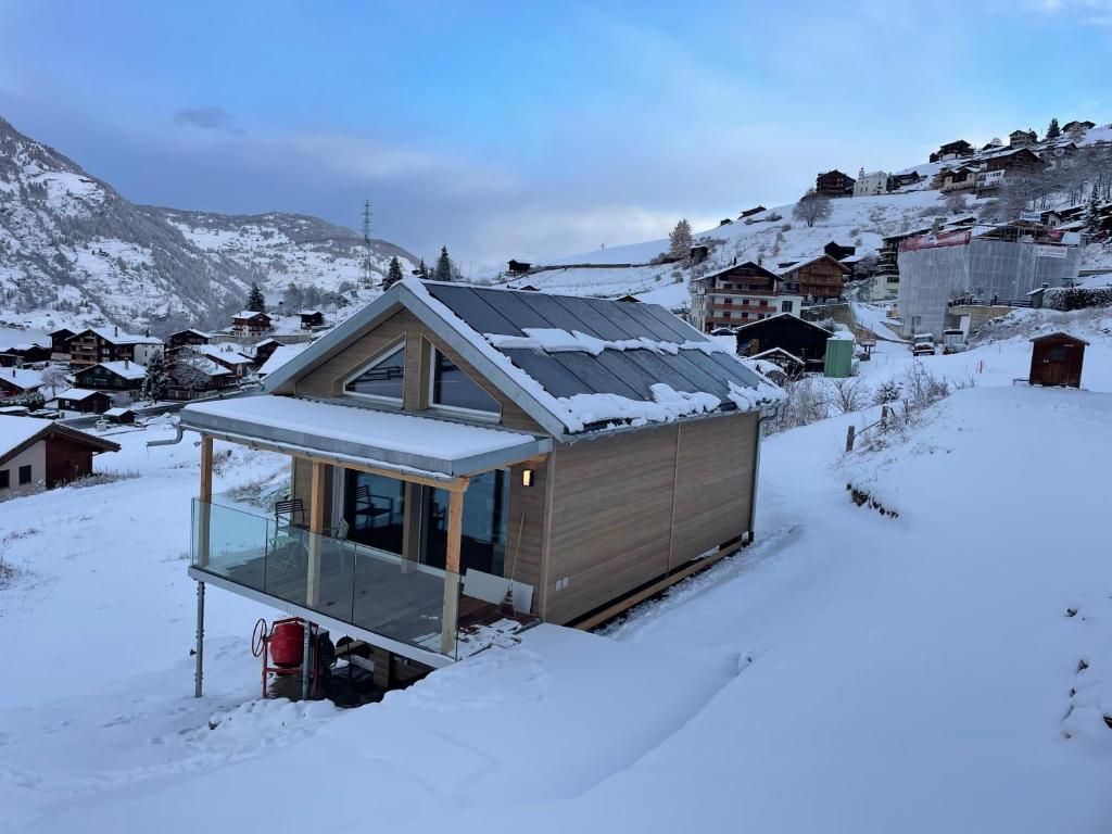 Una pequeña casa en la nieve en un pueblo. en Tiny Barrhorn, en Grächen
