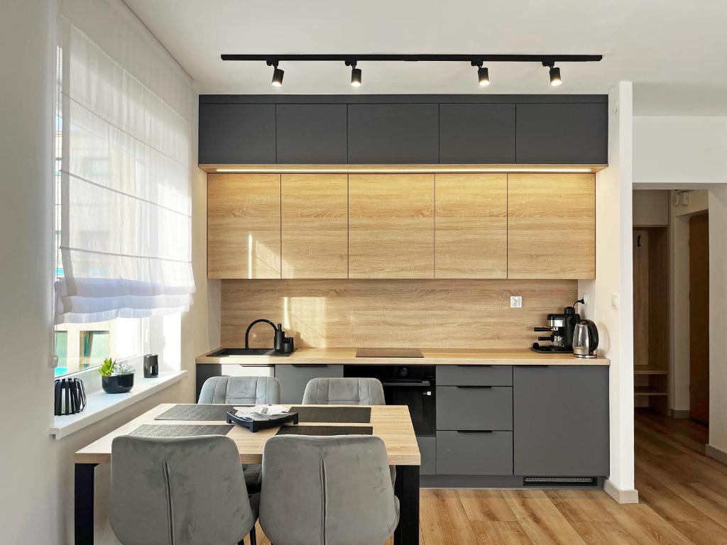 una cucina con tavolo, sedie e bancone di Poznań Wilda -Apartament Fabryczna a Poznań