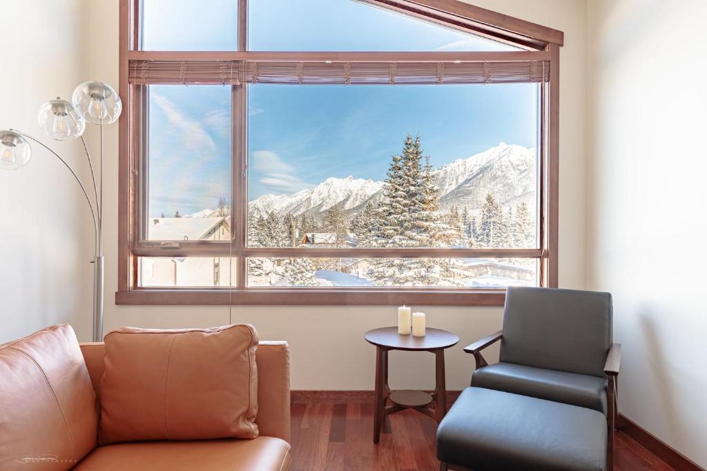 a living room with a couch and a large window at El Paraiso - Luxury Downtown Penthouse in Canmore