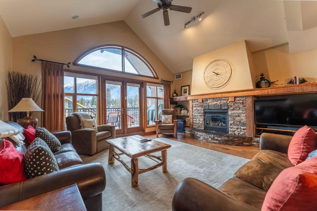 a living room with couches and a fireplace at Cascade Penthouse by Canadian Rockies Vacation Rentals in Canmore