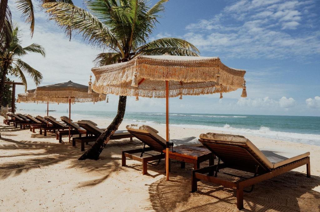 a row of chairs and umbrellas on a beach at Amaia Trancoso Hotel in Trancoso