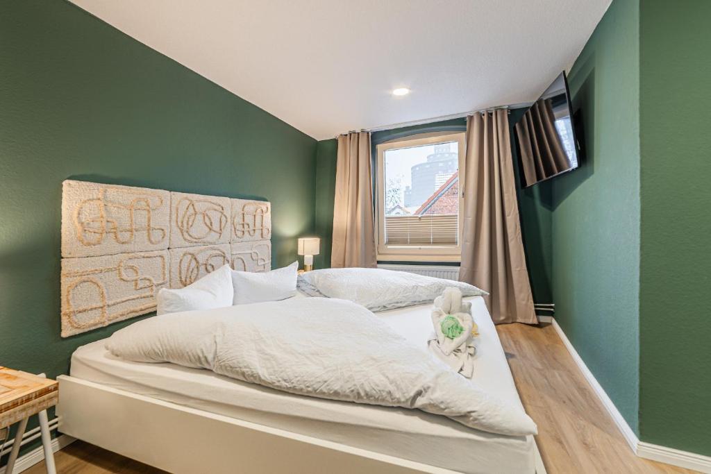 Un dormitorio con una cama con paredes verdes y una ventana en Hotel Seepferdchen Zimmer 6 Eckernförde Self-Check-In, en Eckernförde