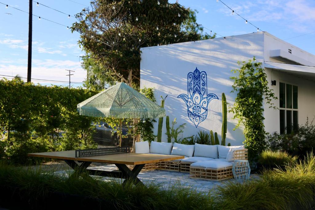 a patio with a table and a couch and an umbrella at Aliza Hotel in Los Angeles