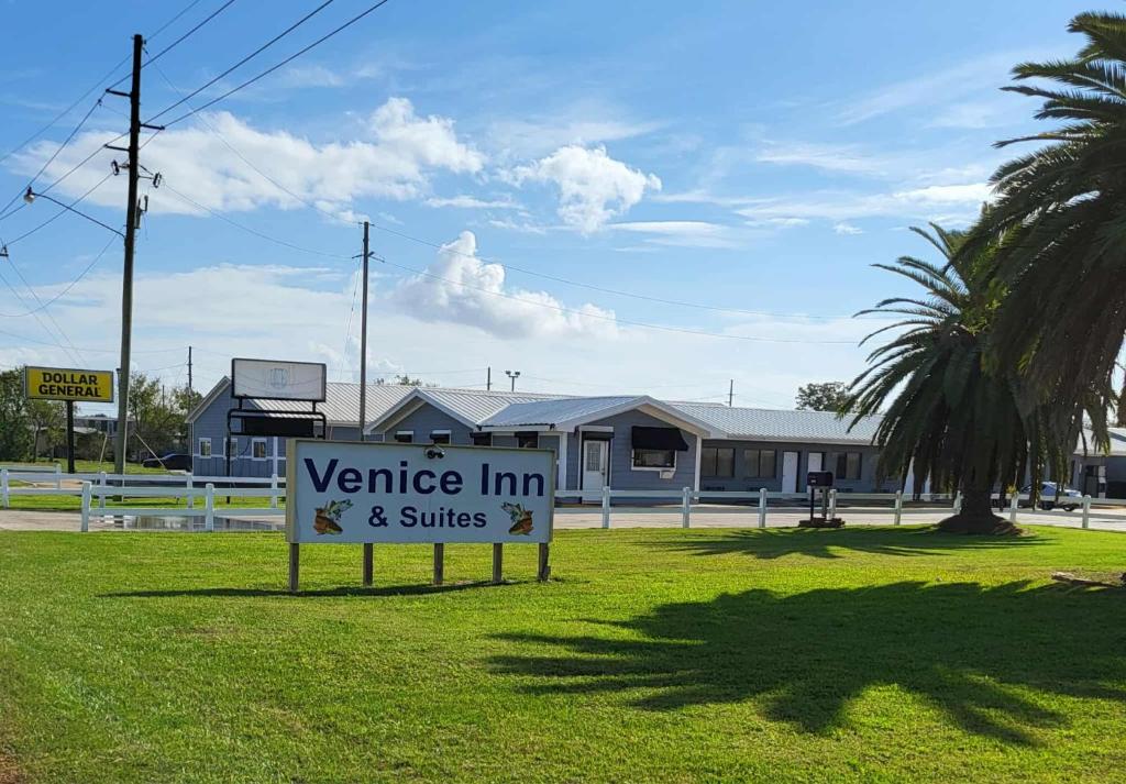 a sign in the grass in front of a building at Venice Inn Motel in Venice