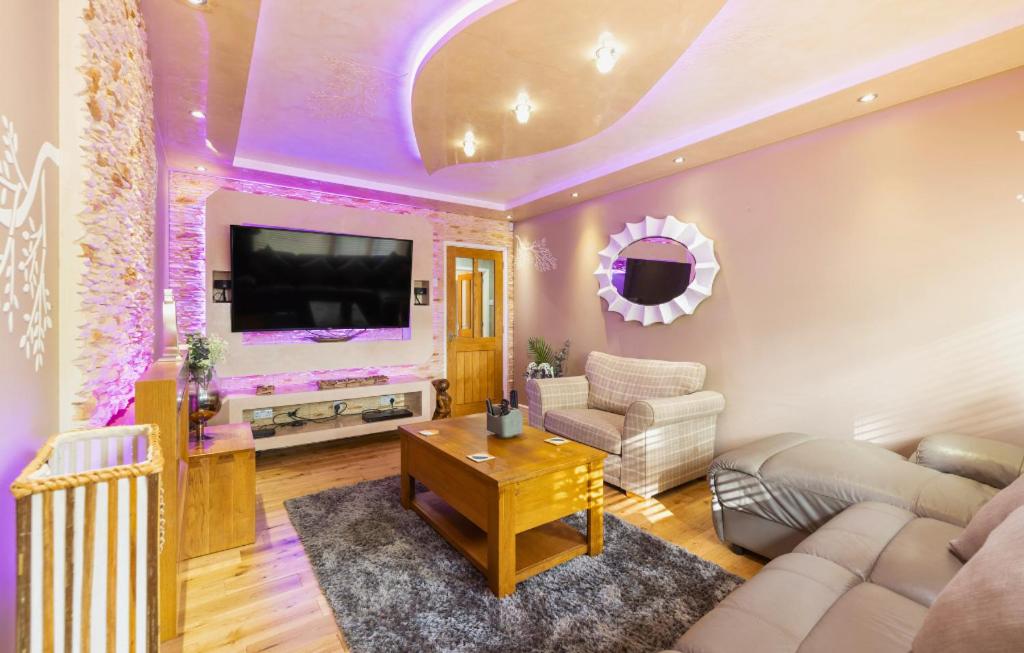 uma sala de estar com um sofá e uma TV em Hot Tub and Garden Spacious Unique 3 Bed House em Allesley