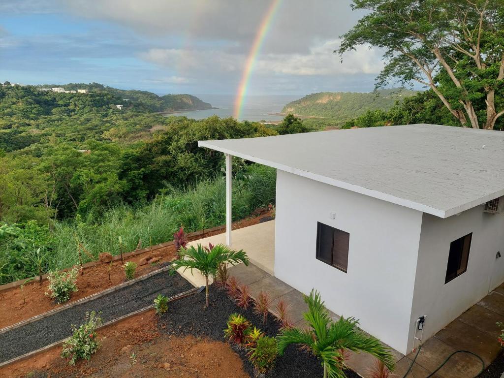un arcobaleno sopra una casa bianca con di Villa BotaNICA guest house a San Juan del Sur
