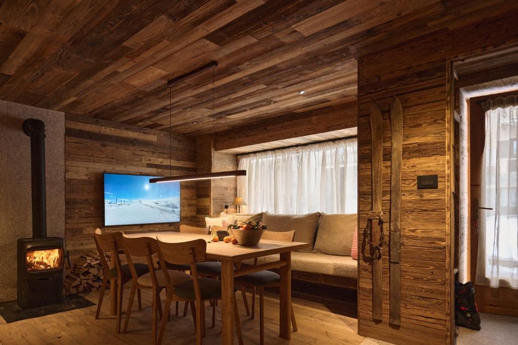 un soggiorno con un tavolo e un divano di Alpine Woodhouse a Valtournenche