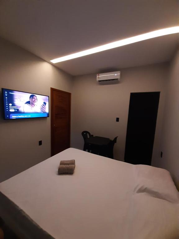 a bedroom with a bed and a tv on the wall at Morada 1 do Jardim do Éden in Parnaíba