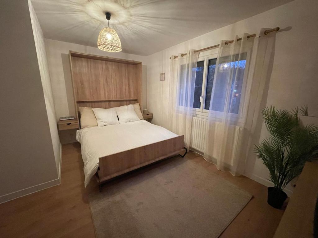 una camera da letto con un letto e una pianta in vaso di Cocon de douceur a La Ravoire