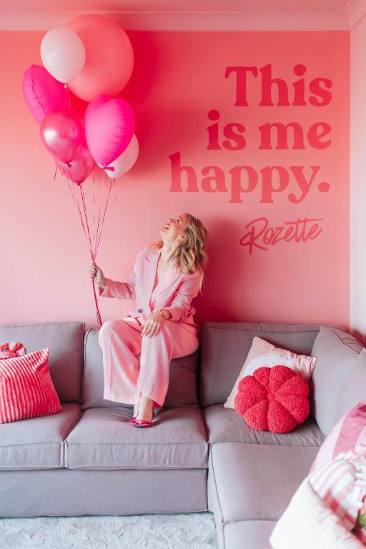 a little girl sitting on a couch holding a bunch of balloons at The Rozette Experience in Ostend