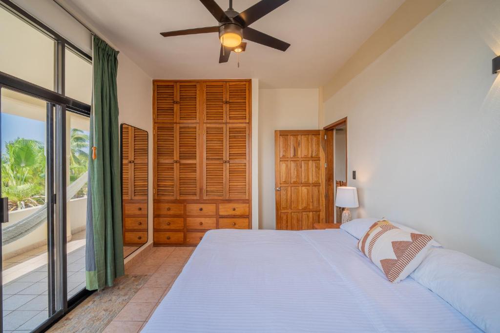 een slaapkamer met een bed en een plafondventilator bij Pacífico Surf in Brisas de Zicatela
