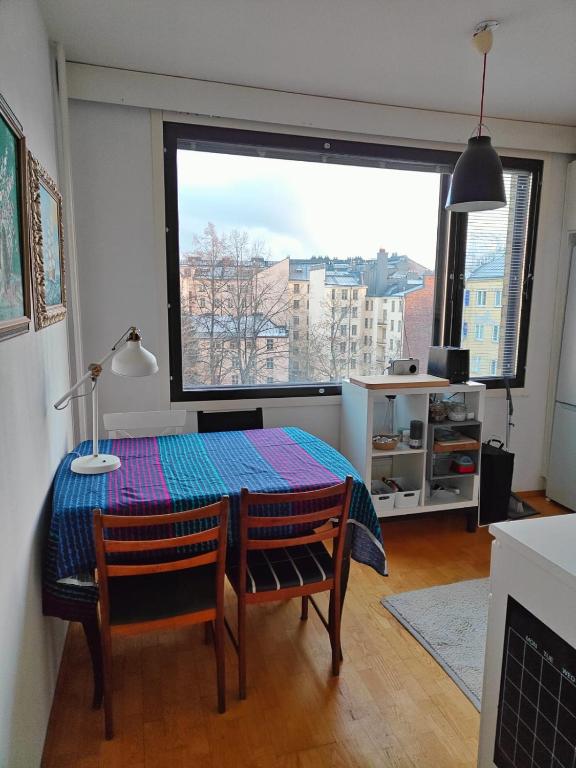 a room with a table and chairs and a large window at Spacious Apartment in Kallio in Helsinki
