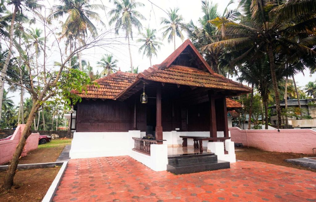 a small building with a roof on top of a brick yard at The Beach Heritage by Halcyon Traveltech LLP in Kovalam