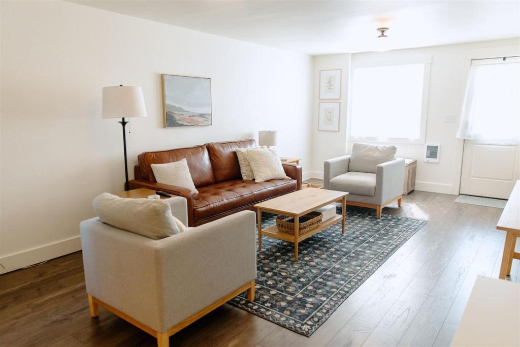 ein Wohnzimmer mit einem Ledersofa und 2 Stühlen in der Unterkunft Boxwood Haven in Moscow