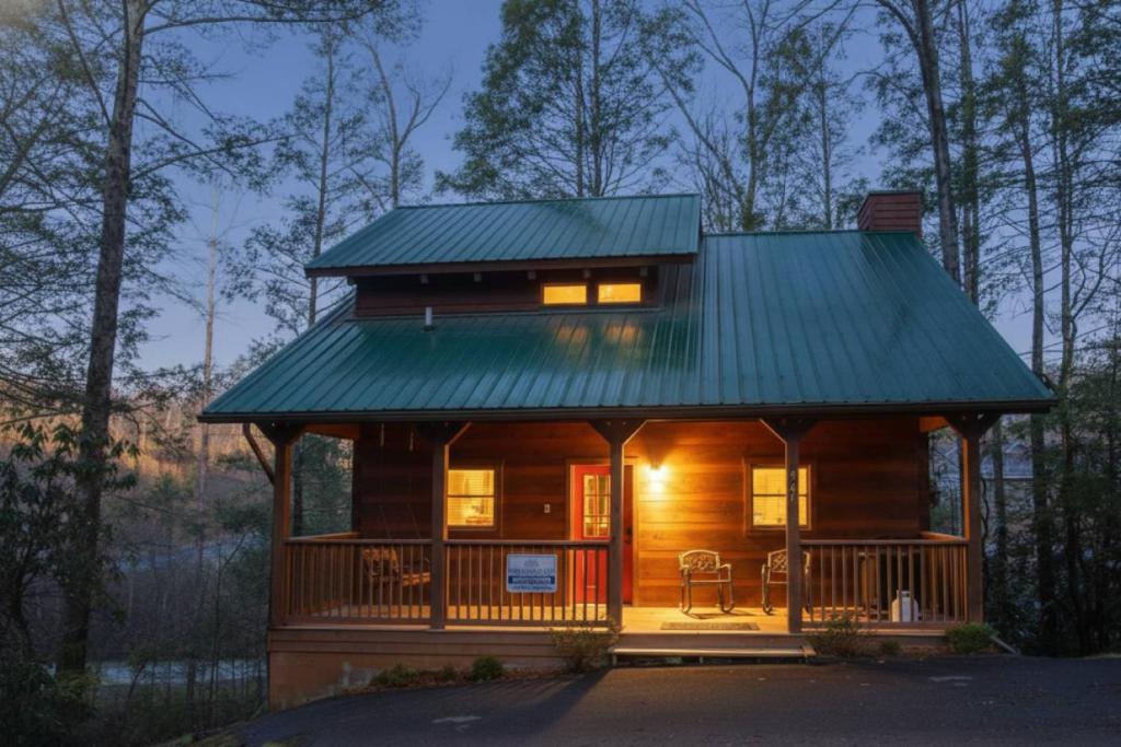 a cabin in the woods with a green roof at Sweet Serenity in Gatlinburg