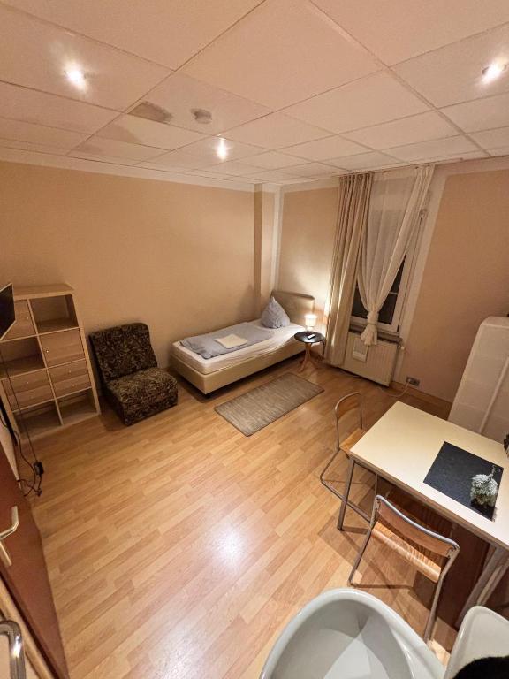 a small room with a bed and a table and chairs at Pension Urbanstraße 46 in Stuttgart
