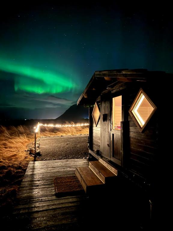 an observation cabin with the northern lights in the sky at Tiny Cabin Under the Northern Lights in Hvalfjarðarsveit