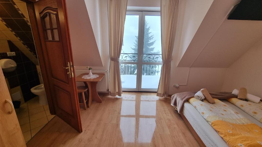 a bedroom with a bed and a large window at Willa u Skrajnioka in Czerwienne