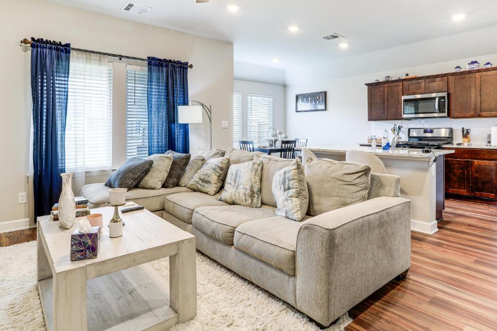 a living room with a couch and a kitchen at Explore Baton Rouge and LSU Family Home with Yard in Baker