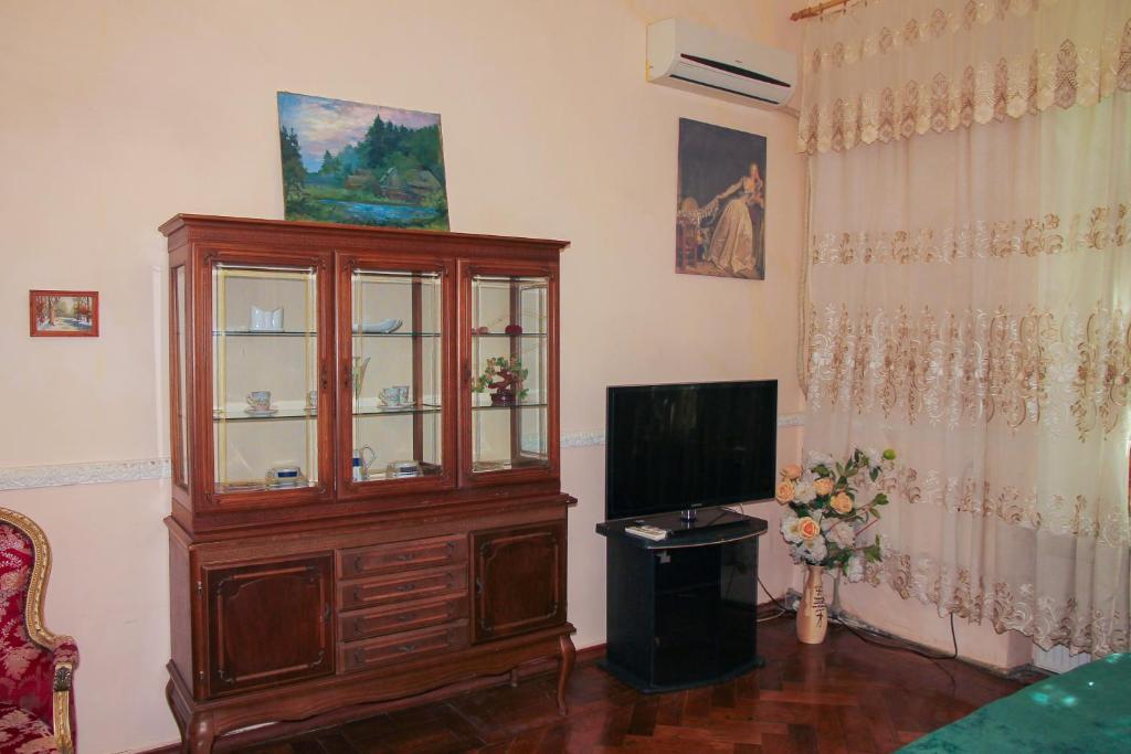 een woonkamer met een grote houten kast met een televisie bij Sadovaya Historical apartment in Odessa