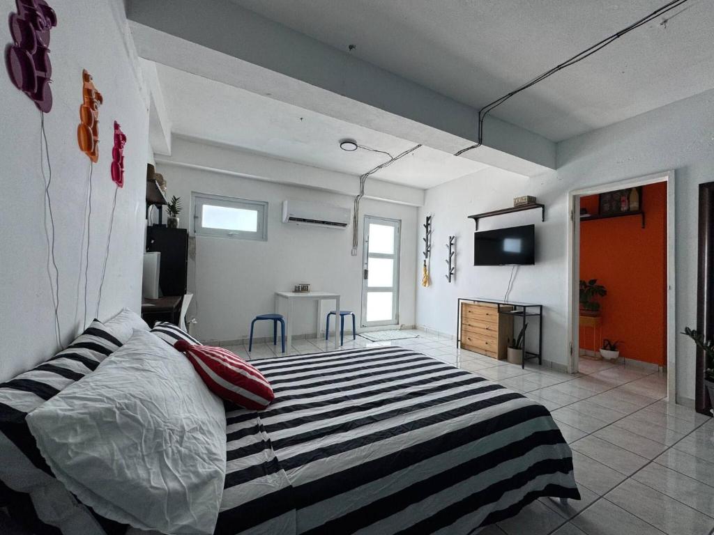 圣胡安D Alexa Mini PH RoofTop的卧室里有一张床和一台电视机