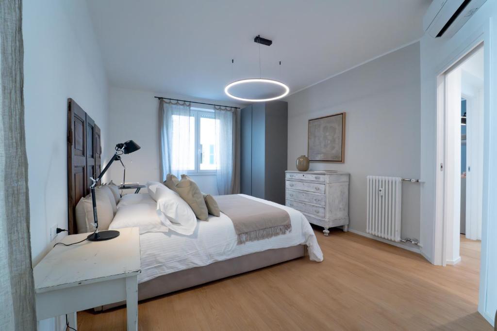 een slaapkamer met een bed en een bureau met een lamp bij Blue chic Suite CentroBergamo in Bergamo
