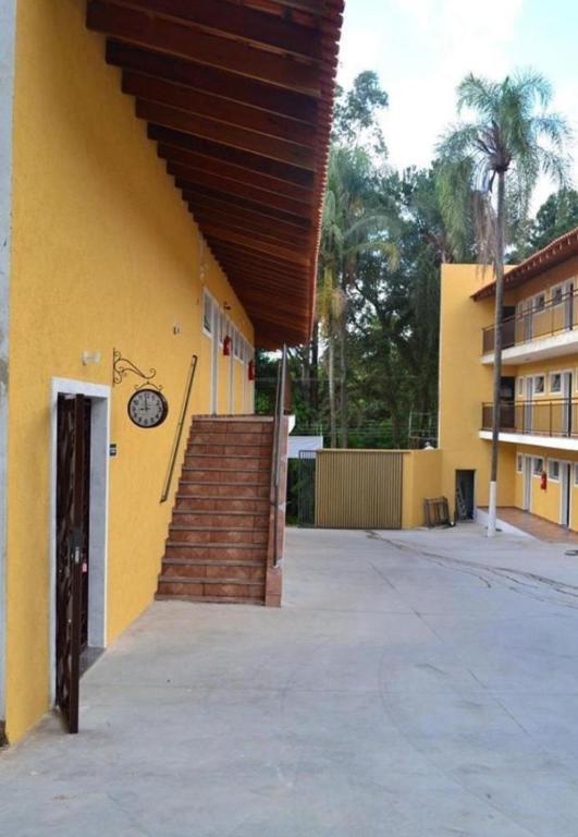 a yellow building with a staircase leading up to a building at Hotel Portal do Eden in Sorocaba