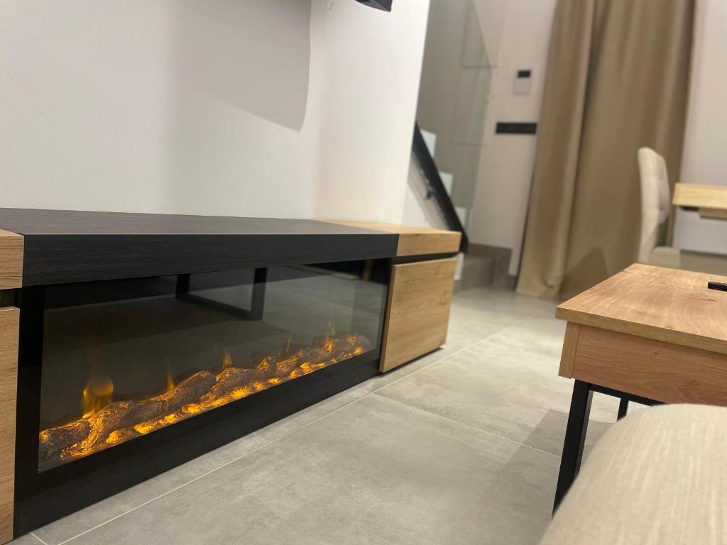 einen Kamin im Wohnzimmer mit einem Tisch in der Unterkunft Cabana Blanca Turisme Rural in Solsona