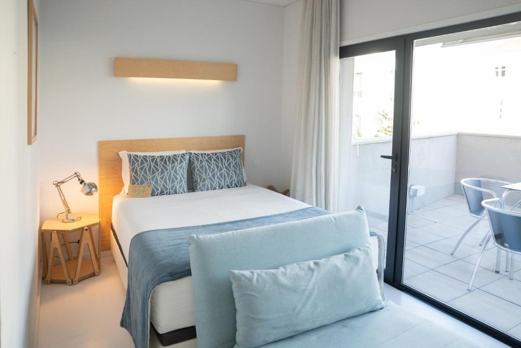 a bedroom with a bed with a blue blanket at I Loft Porto in Porto