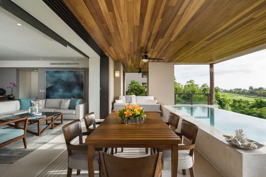 een eetkamer met een tafel en een zwembad bij Tropical Oceanview Condo Punta Mita in Punta Mita