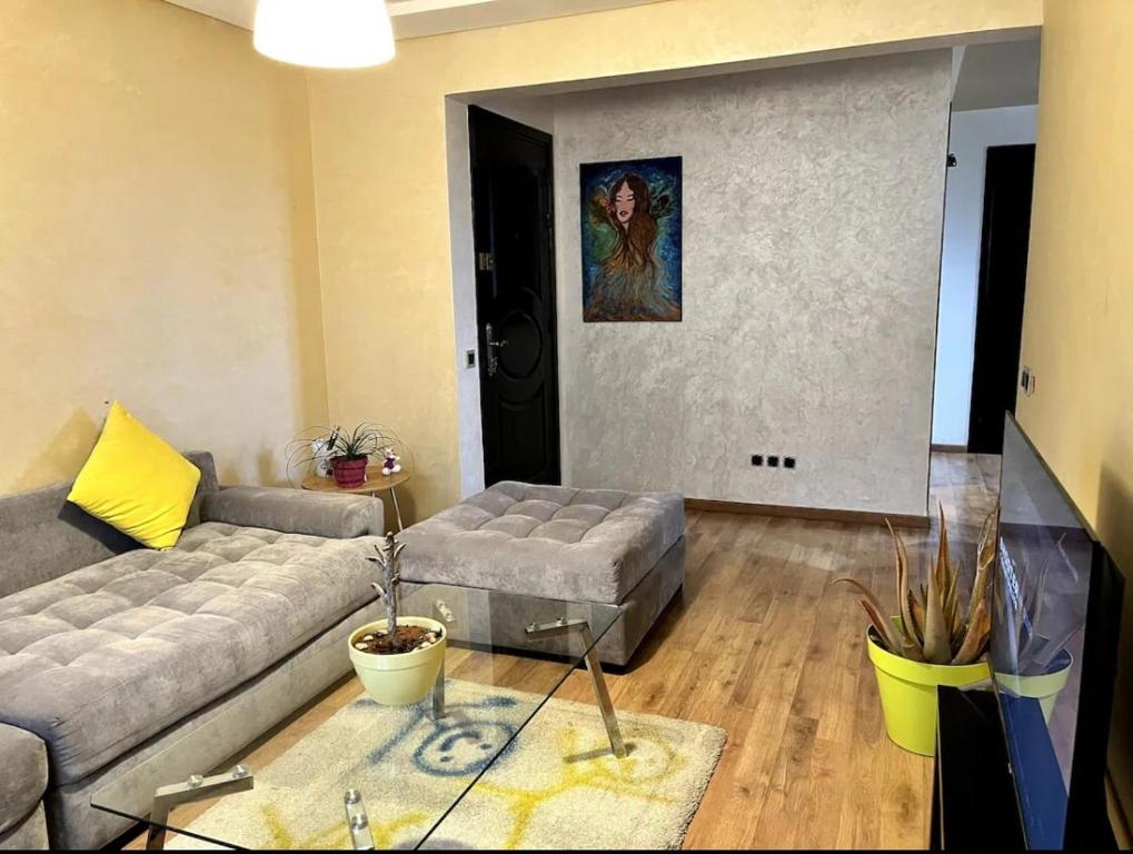 una sala de estar con un sofá y una mesa en Moderne appartement in a good location, en Casablanca