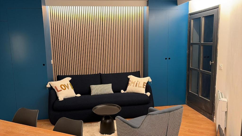 een woonkamer met een zwarte bank en een tafel bij Cosy Arc 1950, Ski-in Ski-out with Interior Swimming Pool, Sauna & Hammam in Arc 1950